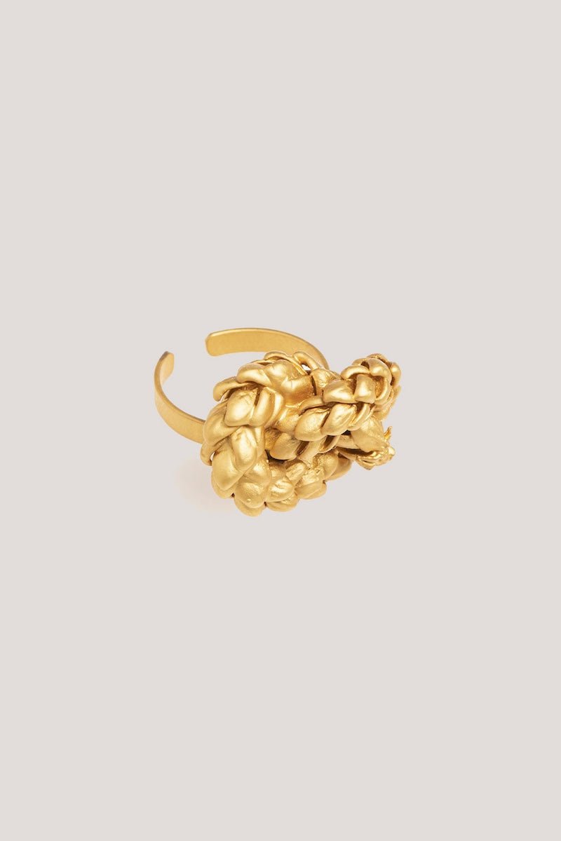 Image of a gold ring with a knot design. The purpose of this image is to highlight the ring by Alma Jewelry.