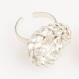 Image of a silver ring with a knot design. The purpose of this image is to highlight the ring by Alma Jewelry.