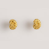 Image of gold earrings with a knot design. The purpose of this image is to highlight the earrings by Alma Jewelry.