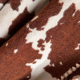 Close-up of brown and white cow print fabric.