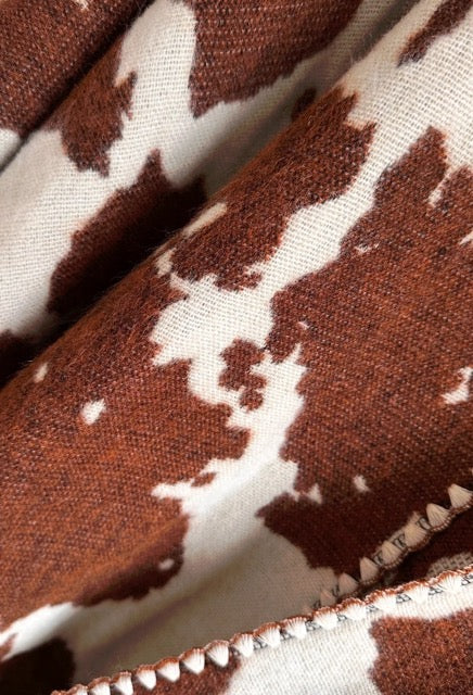 Close-up of brown and white cow print fabric.