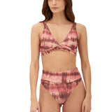 Woman wearing a pink tie-dye bikini set on a white background.