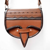 A two-toned brown leather crossbody saddle bag with multiple pockets and hardware accents, handmade in Colombia.