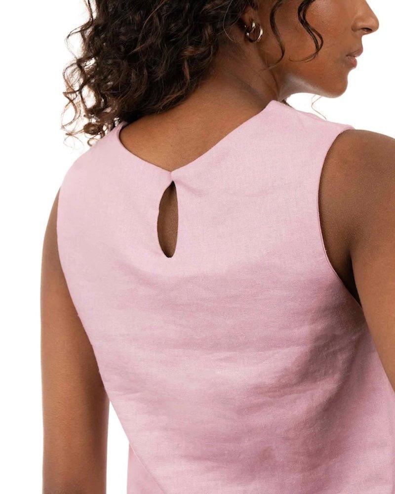 Close up image of a woman wearing a linen top and pants. She's standing behind a white background. The purpose of this image is to highlight the clothing, which is made in Colombia and sold at EVAMAIA Boutique in Studio City, CA.