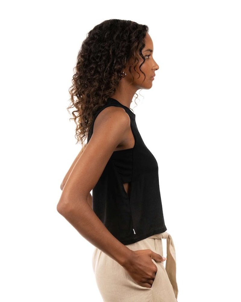 Woman wearing a linen top and pants. She's standing behind a white background. The purpose of this image is to highlight the clothing, which is made in Colombia and sold at EVAMAIA Boutique in Studio City, CA.