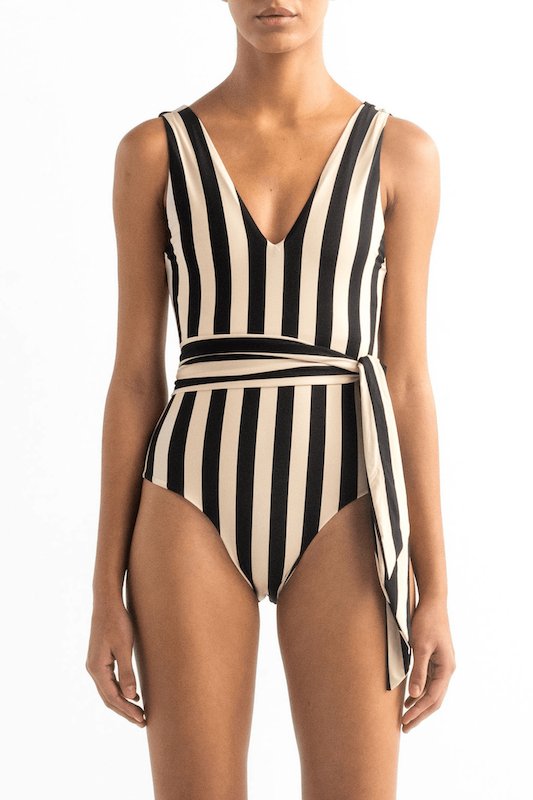 Model wearing the Vero one piece with black and white stripes and a matching belt