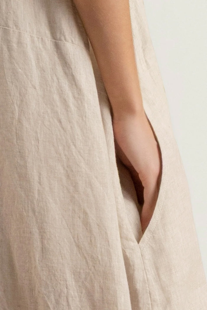Close-up of a beige fabric with a hand peeking out from a pocket.