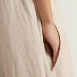 Close-up of a beige fabric with a hand peeking out from a pocket.