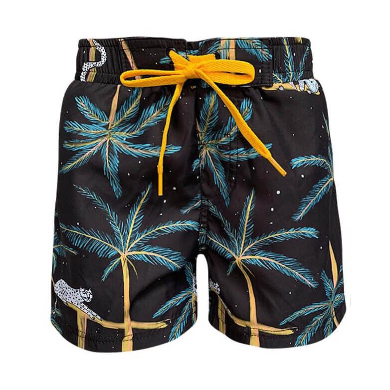 Black swim trunks for boys. These shorts have a yellow drawstring with a starry night jungle theme. The design features details like a leopard, snake, and sleepy sloth.