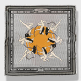 La Gaitana Scarf by Plissé. Image of 8 Cacica Gaitana in a circle over a yellow dot. The whole deign over over a light grey geometric pattern with a frame like border and arrow border. The overall tone of the scarf is a washed out grey.