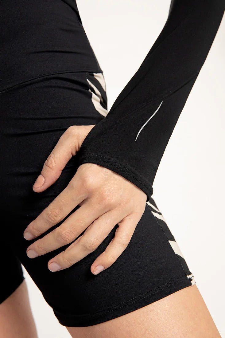 A close up of a turtle neck with holes for thumbs in the sleeves.