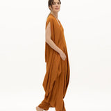 Image of woman wearing a flowy jumpsuit against a white background. The purpose of this image is to highlight the jumpsuit from NAOS, which is for sale at EVAMAIA boutique in Studio City, CA.