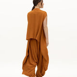 Image of woman wearing a flowy jumpsuit against a white background. The purpose of this image is to highlight the jumpsuit from NAOS, which is for sale at EVAMAIA boutique in Studio City, CA.