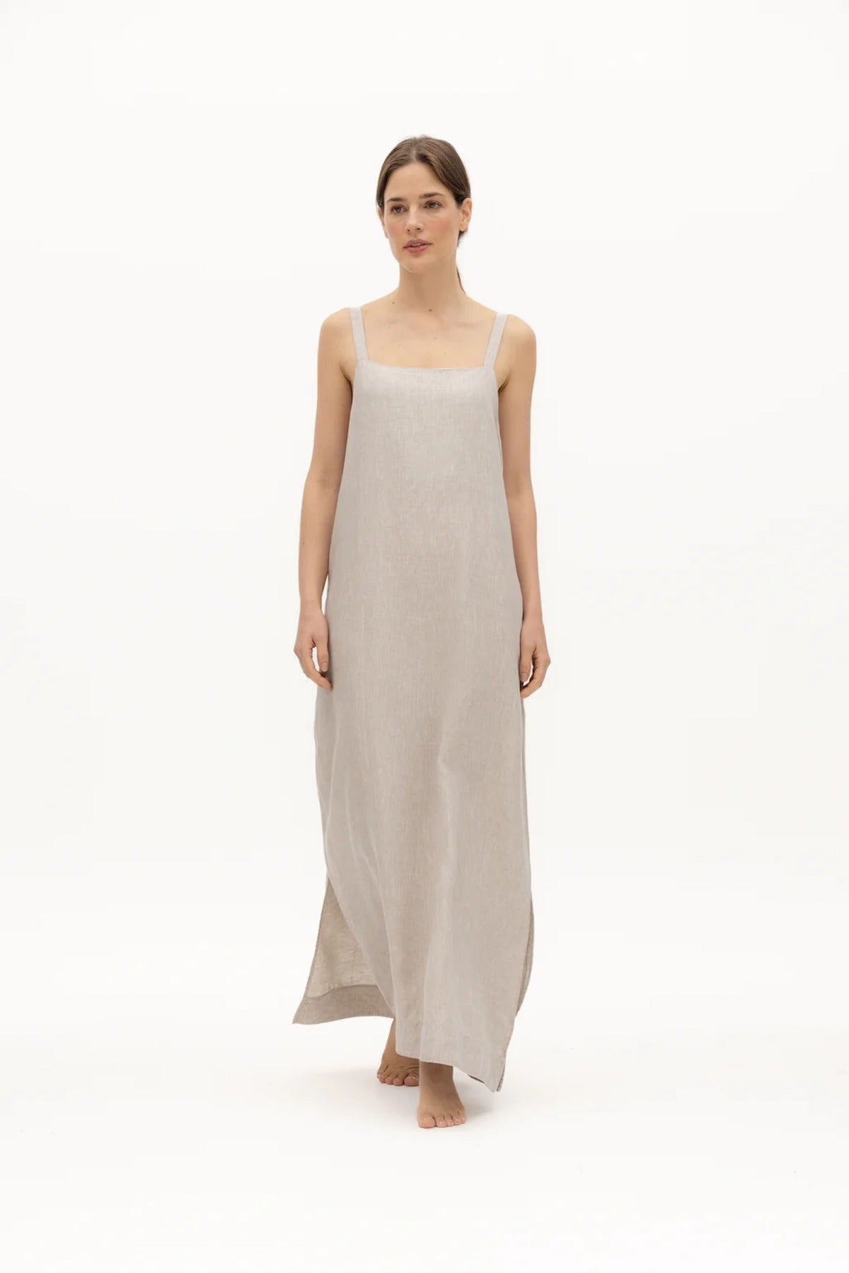 Image of a woman wearing a long dress with pockets and spaghetti straps that was made in Colombia by NAOS. The purpose of this image is to highlight the dress, which is for sale at EVAMAIA boutique in Studio City, CA and online.