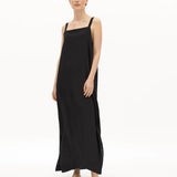 Image of a woman wearing a long dress with pockets and spaghetti straps that was made in Colombia by NAOS. The purpose of this image is to highlight the dress, which is for sale at EVAMAIA boutique in Studio City, CA and online.