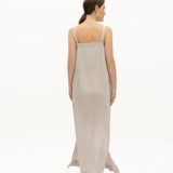 Image of a woman wearing a long dress with pockets and spaghetti straps that was made in Colombia by NAOS. The purpose of this image is to highlight the dress, which is for sale at EVAMAIA boutique in Studio City, CA and online.