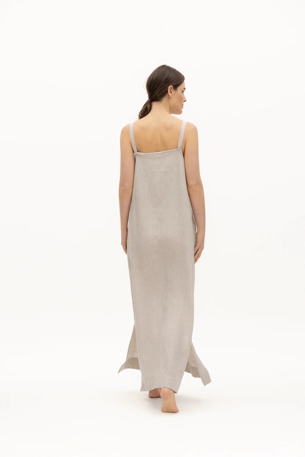 Image of a woman wearing a long dress with pockets and spaghetti straps that was made in Colombia by NAOS. The purpose of this image is to highlight the dress, which is for sale at EVAMAIA boutique in Studio City, CA and online.