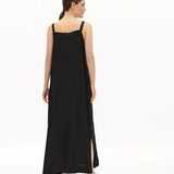 Image of a woman wearing a long dress with pockets and spaghetti straps that was made in Colombia by NAOS. The purpose of this image is to highlight the dress, which is for sale at EVAMAIA boutique in Studio City, CA and online.