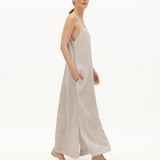 Image of a woman wearing a long dress with pockets and spaghetti straps that was made in Colombia by NAOS. The purpose of this image is to highlight the dress, which is for sale at EVAMAIA boutique in Studio City, CA and online.