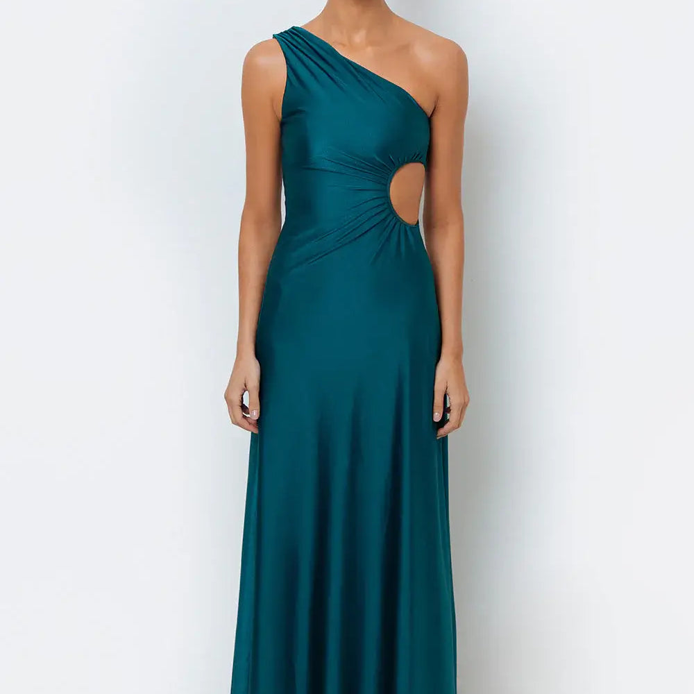 A model wearing wearing an emerald green maxi dress with a one-shoulder design and a side cutout.