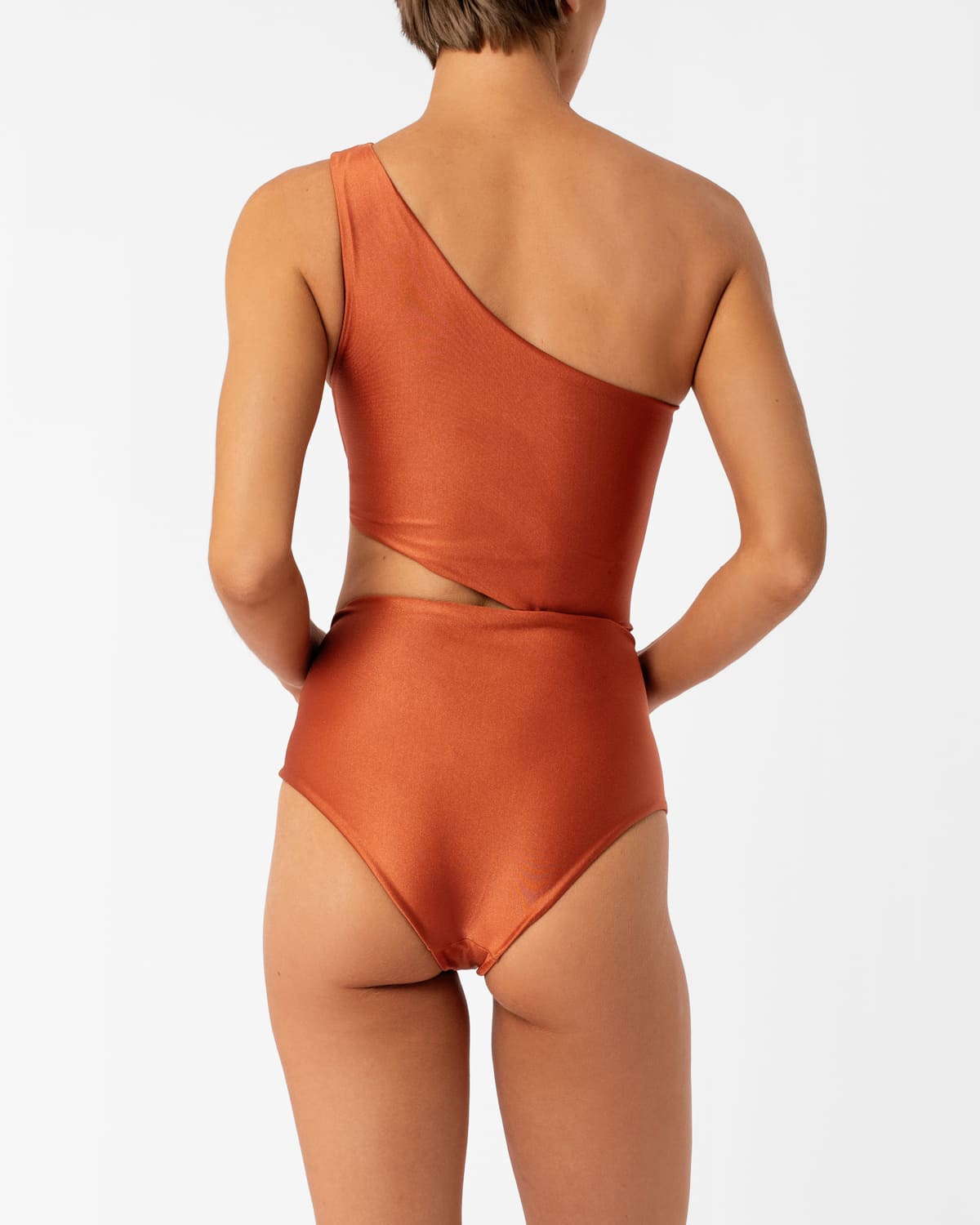Diana orange one-shoulder one-piece swimsuit by Encantadore with ruching and side cutout, back view. Available at EVAMAIA in Studio City, Los Angeles.