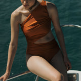 Orange one-shoulder swimsuit with rouching and side cut. 