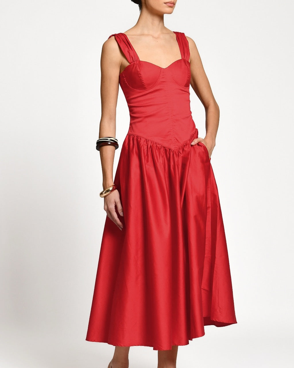 Red dress worn by a woman on a white background.