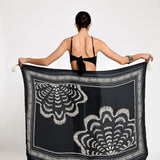 Woman holding a black and white patterned scarf.