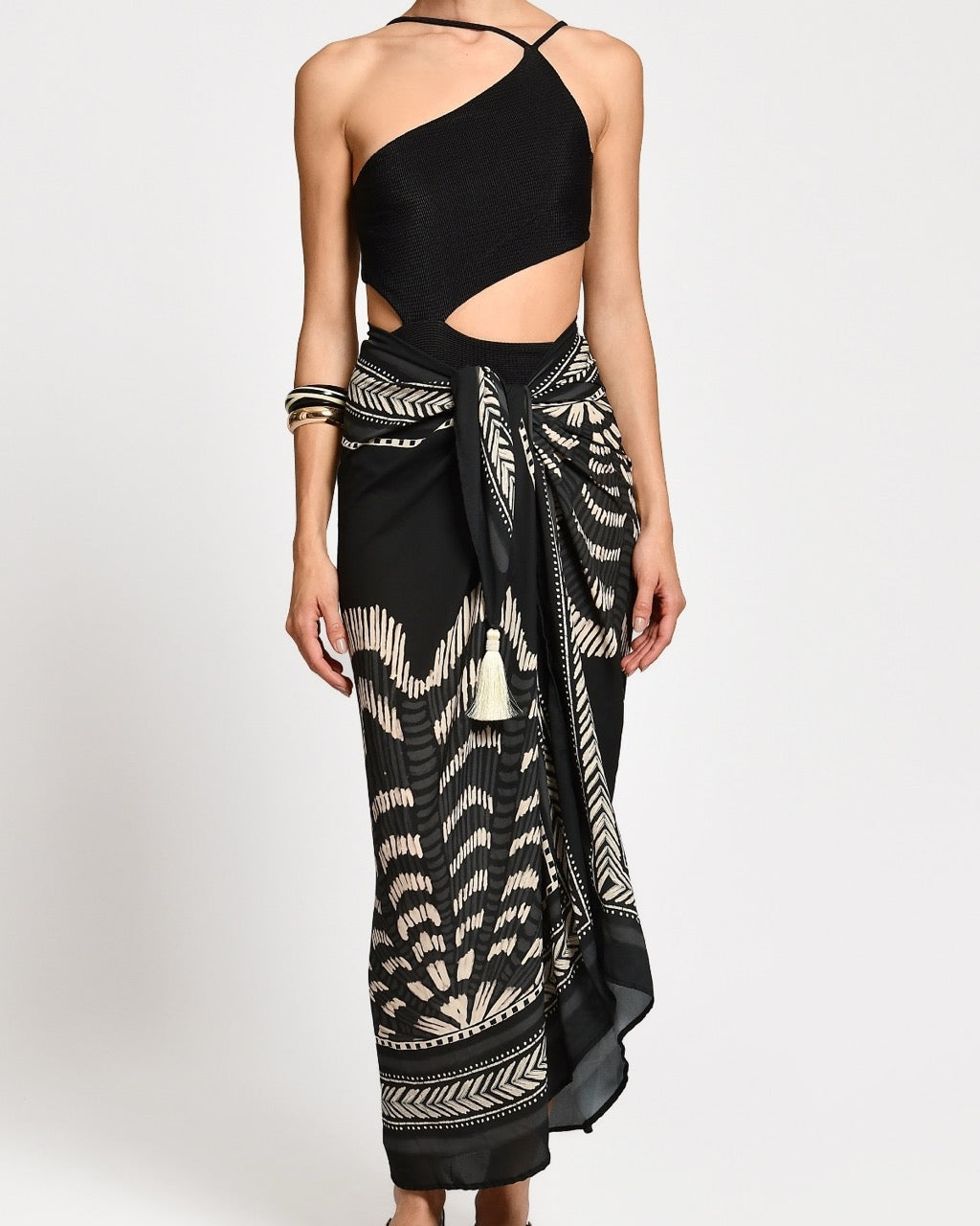 Black one-shoulder bathing with a wrap skirt with black and white patterns. 