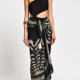 Black one-shoulder bathing with a wrap skirt with black and white patterns. 