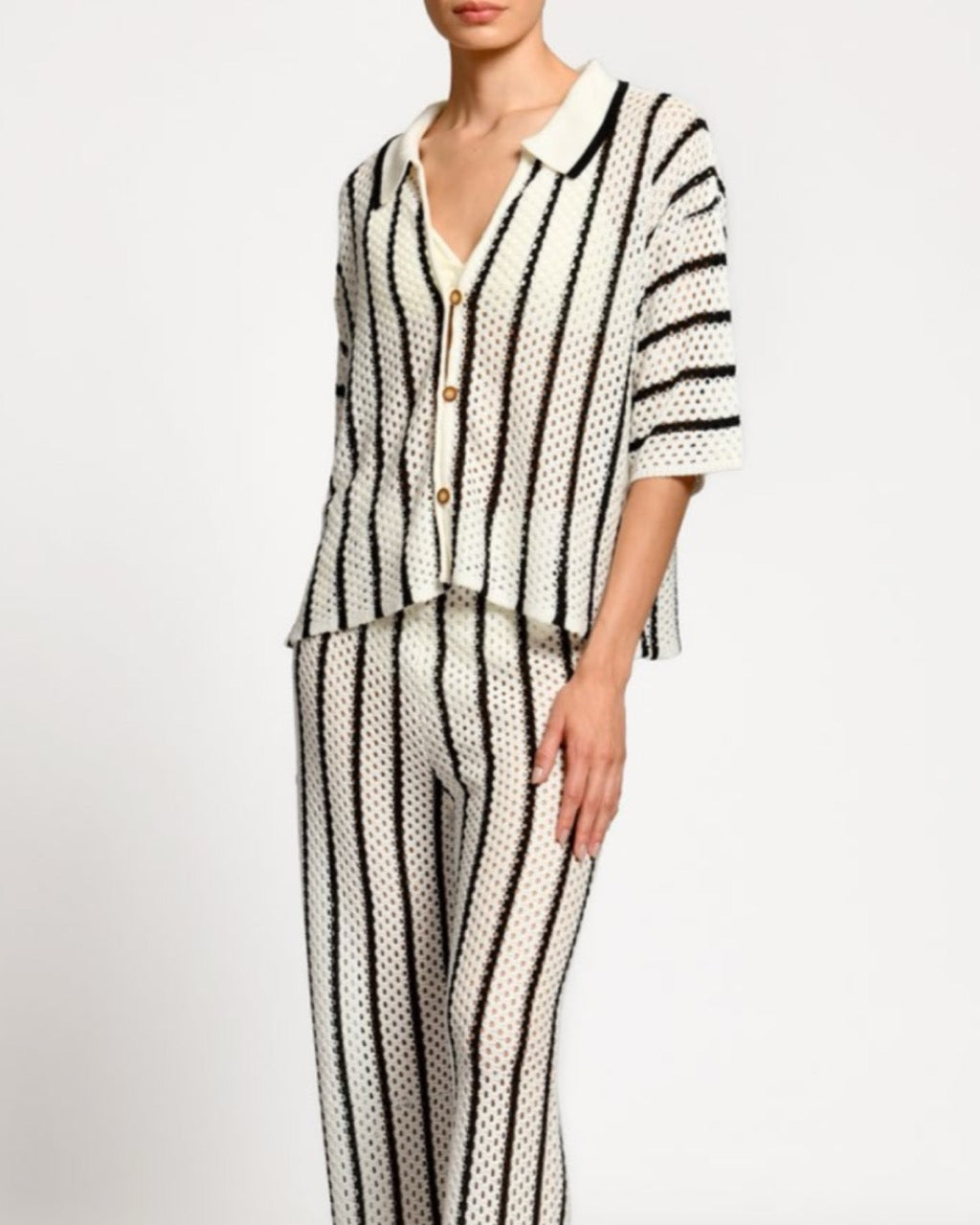 Person wearing a black and white striped matching set on a white background.
