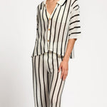 Person wearing a black and white striped matching set on a white background.