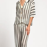 Person wearing a black and white striped matching set on a white background.