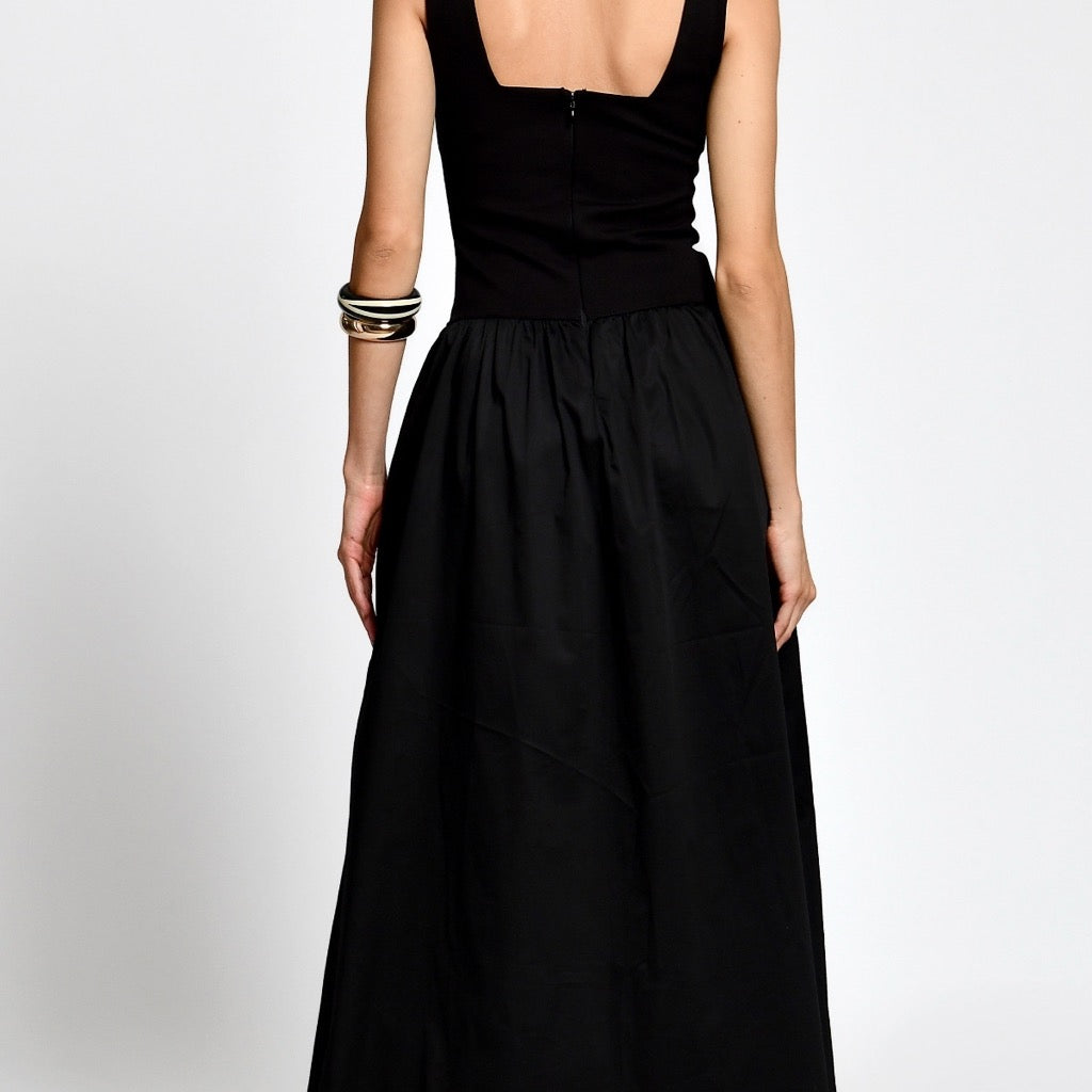 Woman wearing a black dress on a white background.