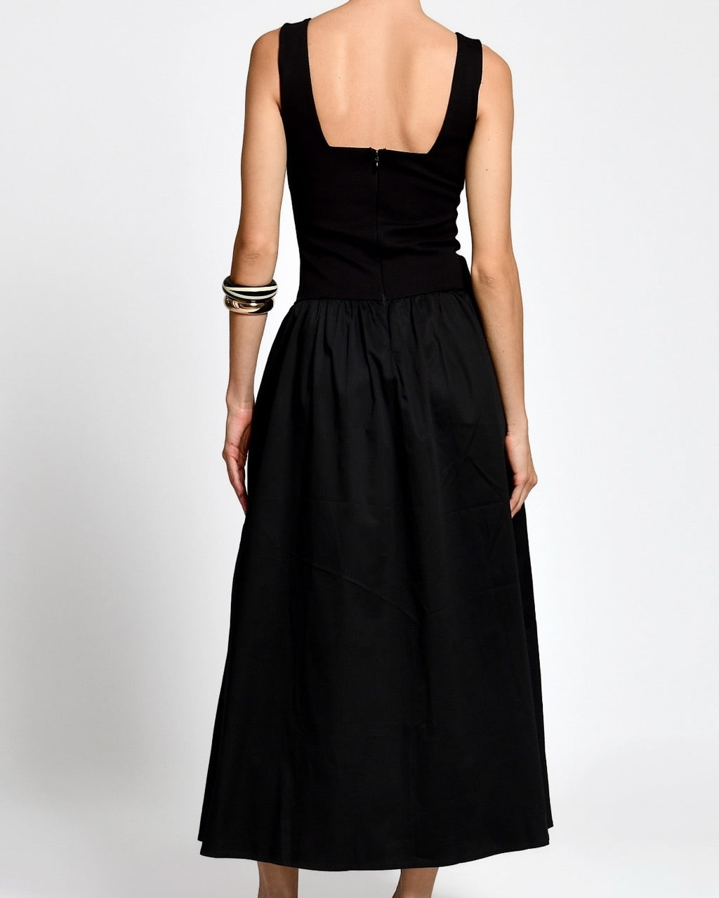 Woman wearing a black dress on a white background.