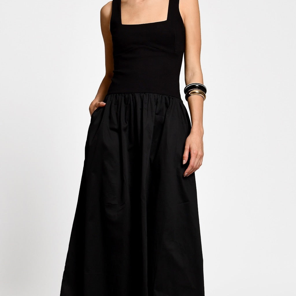 Black dress worn by a woman on a white background.