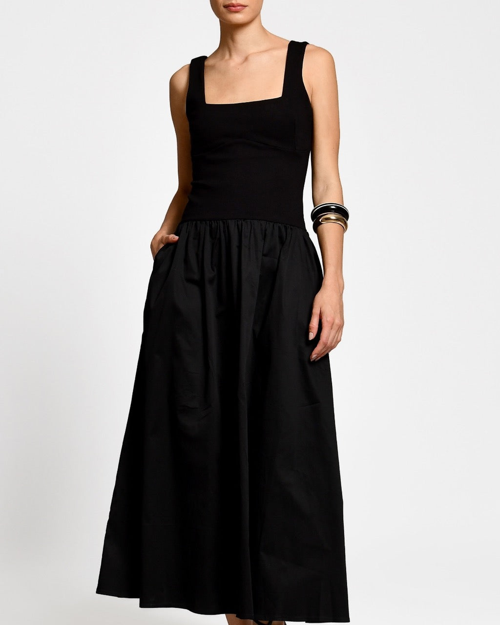 Black dress worn by a woman on a white background.