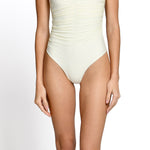 Model wearing Ivory one piece swimsuit with deep V neckline at EVAMAIA.