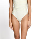 Model wearing Ivory one piece swimsuit with deep V neckline at EVAMAIA.