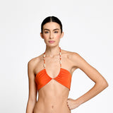 Woman wearing an orange bikini against a white background