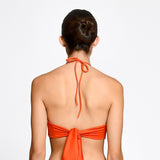 Orange bikini top worn by a model on a white background