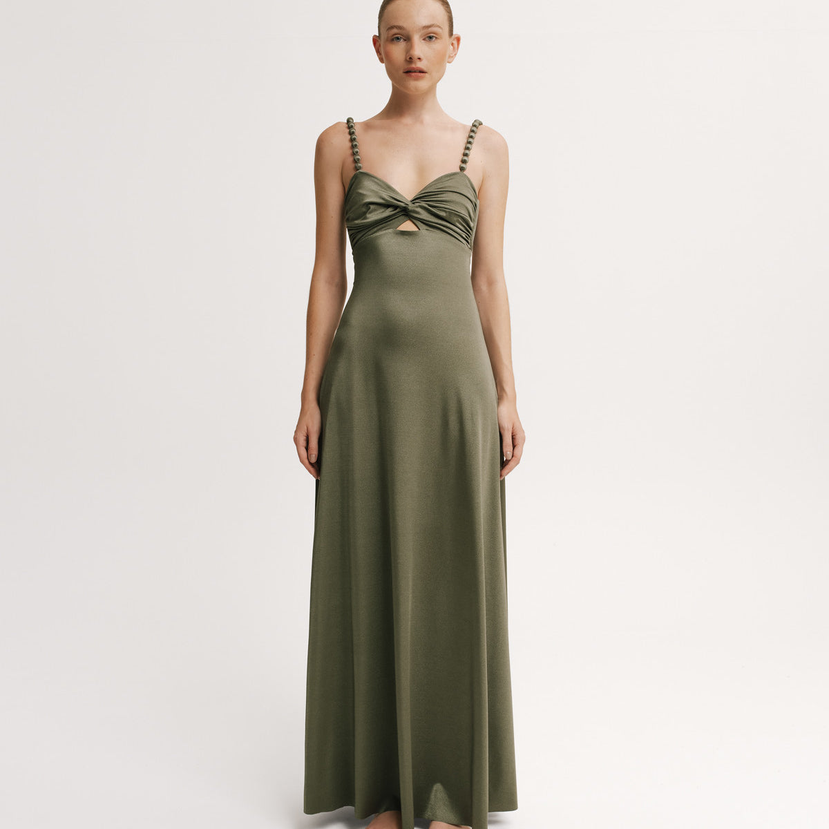 Woman wearing a green evening gown on a white background.