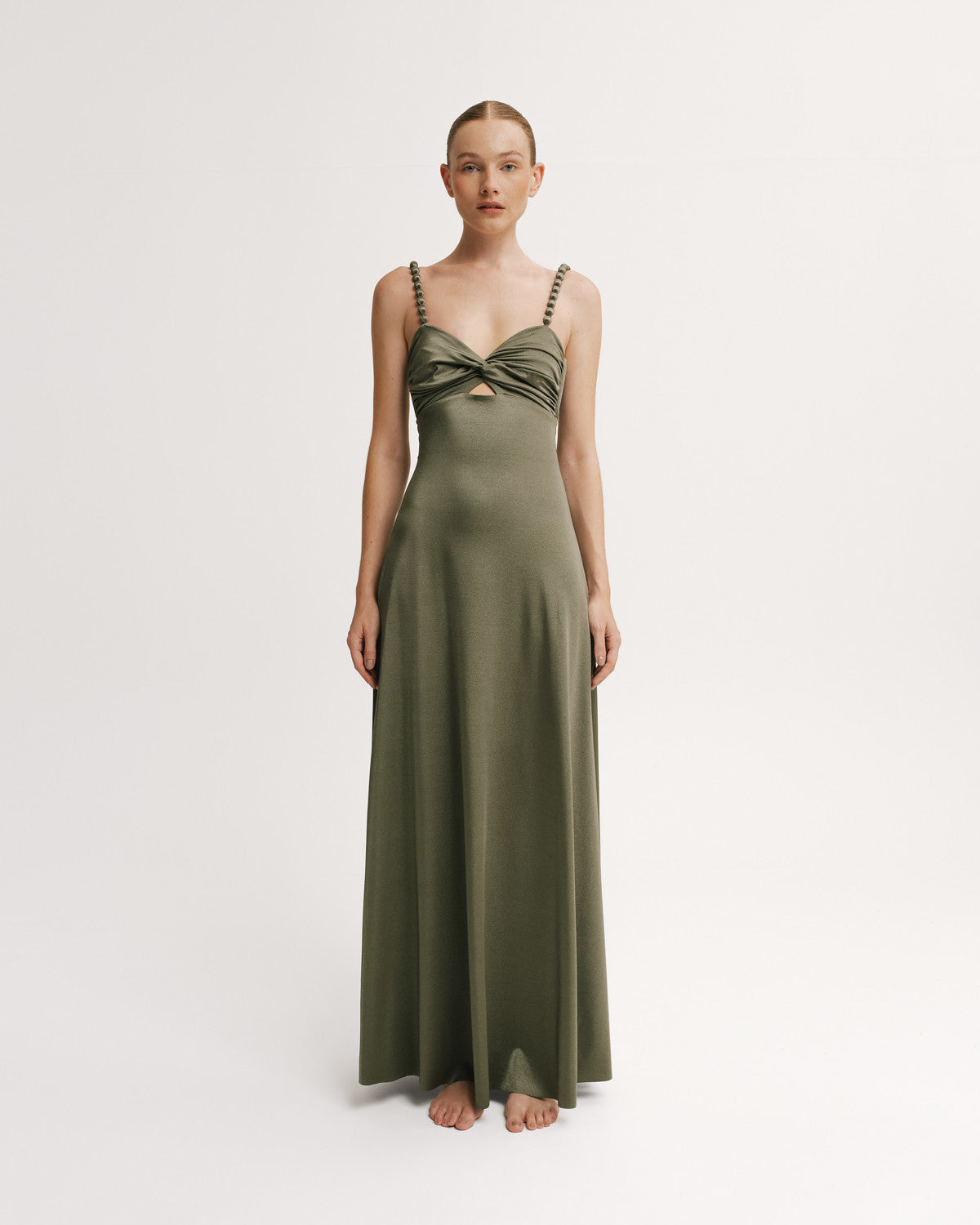 Woman wearing a green evening gown on a white background.