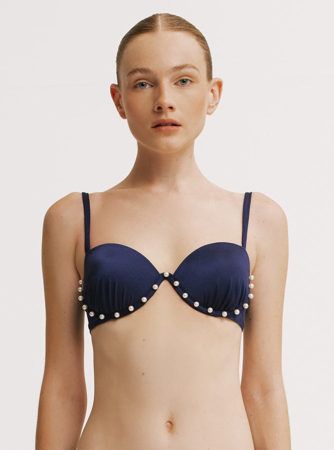 Navy blue bikini top with pearl embellishments on a plain background.