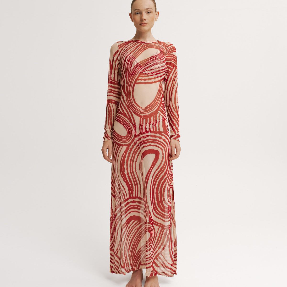 Model wearing a red and white patterned dress on a white background.