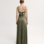 Woman wearing a green evening gown with cut-out back on a white background