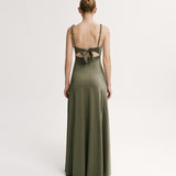 Woman wearing a green evening gown with cut-out back on a white background