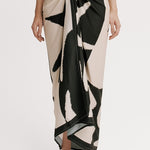 Person wearing a black and white patterned wrap skirt on a plain background