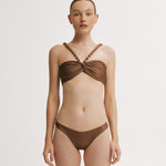 Woman wearing a brown bikini set on a plain background.