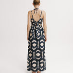 Woman wearing a patterned dress on a white background.